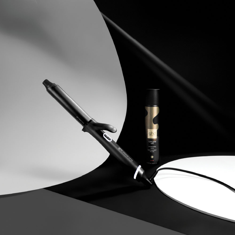 Hair straightener and bottle on a black and white background